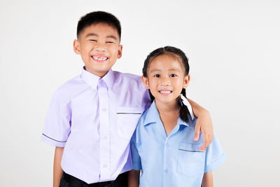 Portrait of smiling couple standing against white background