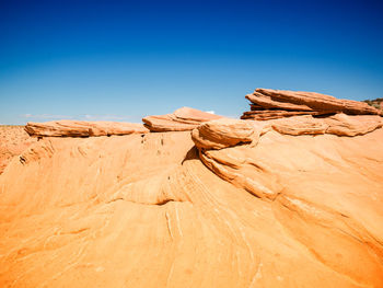 Rock formations in desert against clear blue sky