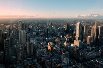 High angle view of modern buildings in city against sky during sunset