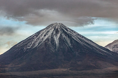 View of volcanic mountain against cloudy sky