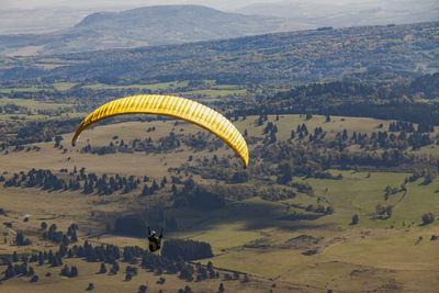 Person paragliding over landscape
