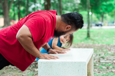 Rear view of father and toddler daughter outdoors.