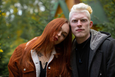Portrait of couple standing in park during autumn