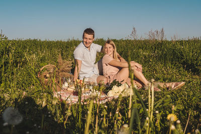 Full length of woman sitting on field against sky