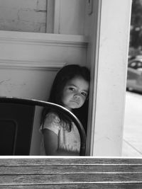 Portrait of smiling girl looking through window