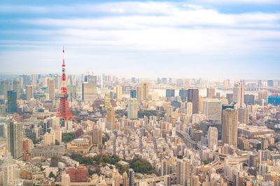 Aerial view of buildings in city against cloudy sky