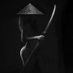 Rear view of woman standing against black background