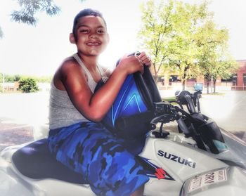 Portrait of smiling girl sitting on car
