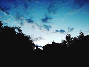 Low angle view of silhouette trees against sky