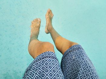 Low section of man relaxing on swimming pool