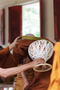 Close-up of man holding wicker basket at home