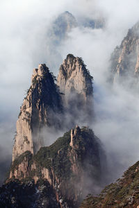 Scenic view of rocky mountains during foggy weather