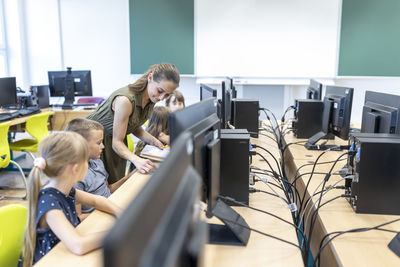 Teacher teaching students through e-learning in class at school