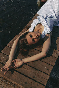 High angle view of young woman sitting on wooden floor