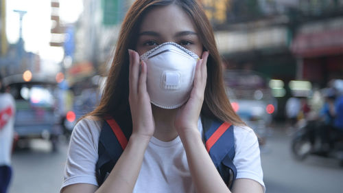 Portrait of young woman drinking from street