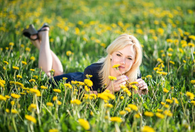 Close-up of young woman lying on field