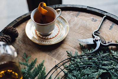 Festive holiday winter hot toddy in teacup on whiskey barrel