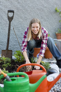 Young woman planting plant, stockholm, sweden