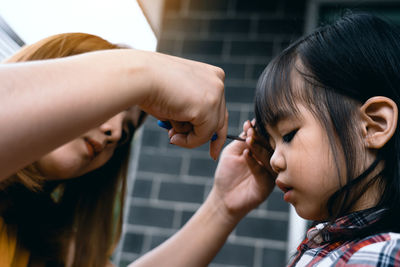 Mother cutting hair of daughter