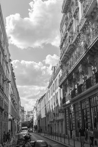 View of city street against cloudy sky