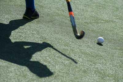 Low section of person playing hockey on field