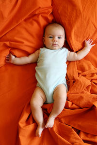 High angle view of cute baby lying on bed