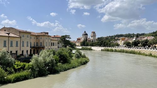 Ponte pietra bridge, river amidst buildings against sky