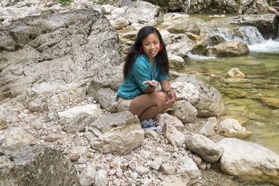Portrait of smiling girl sitting on rock