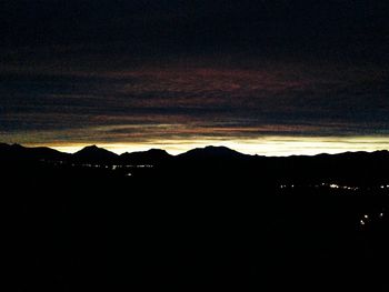 Scenic view of silhouette mountains against sky at sunset