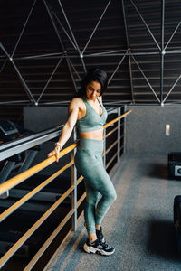 Full length of young woman standing on escalator