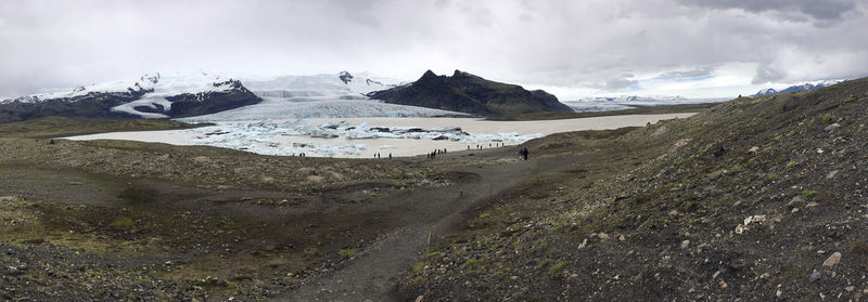 Panoramic view of glaciers and landscape against cloudy sky