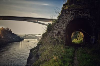 Arch bridge over river against sky