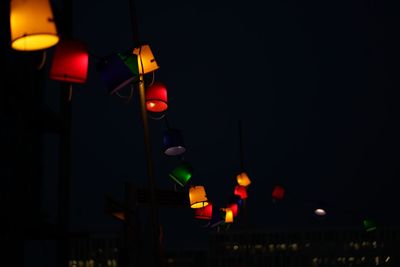 Low angle view of illuminated lighting equipment on street at night