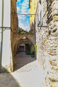 Narrow alley amidst buildings against sky