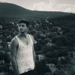 Portrait of young man standing against trees