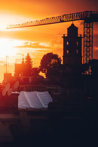 Silhouette buildings against sky during sunset