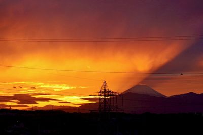 Scenic view of silhouette mountains against romantic sky at sunset