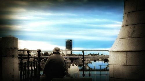 Silhouette of city against cloudy sky