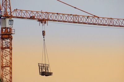 Low angle view of crane against clear sky