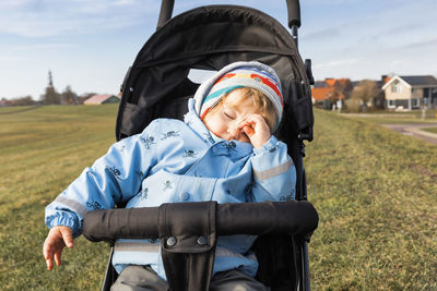 Child sleeping on stroller in park