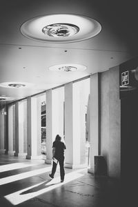 Rear view of man walking in corridor of building