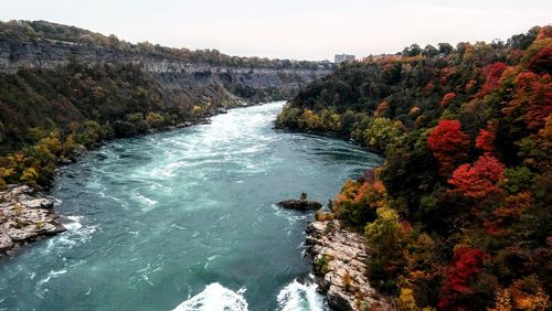 Scenic view of rocks by sea against sky
