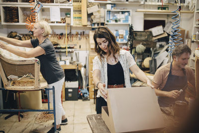 Male and female workers working in upholstery workshop