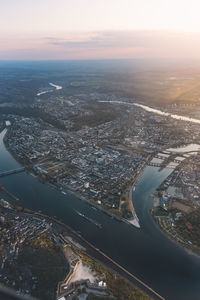 Aerial view of city and buildings against sky during sunset