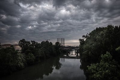 River amidst trees and buildings against sky