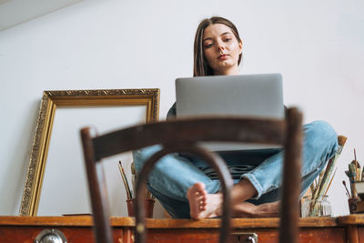 Beautiful woman creative freelancer in casual clothes using laptop on table at home