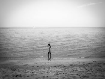 Woman on beach against clear sky