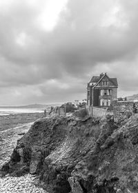 House on beach by sea against sky