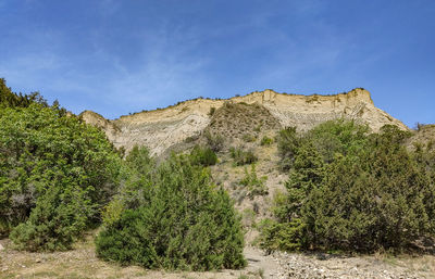 Rock formations on field against sky