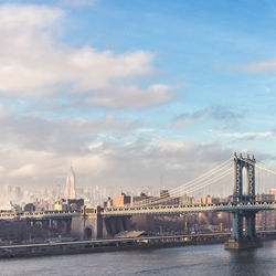 View of bridge over river against cloudy sky